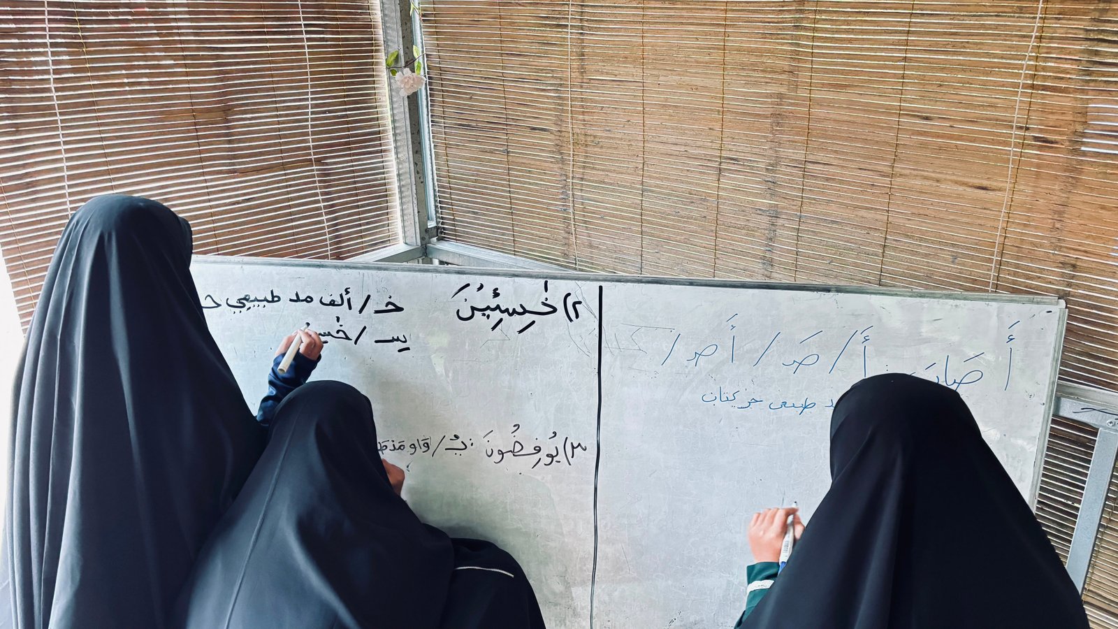 Santriwati menulis huruf Arab di papan tulis di ruang belajar